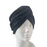 Black turban on a mannequin head against a white background