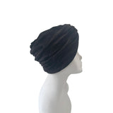 Black turban on a mannequin head against a white background
