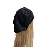 Black beanie on a mannequin head with blonde hair against a white background