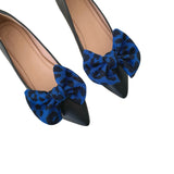 Black shoes with blue leopard print bows on a white background