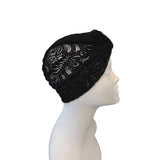Black lace headscarf on a mannequin head against a white background