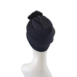 Black turban on a mannequin head against a white background
