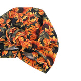 Floral patterned headscarf with orange and green colors on a white background