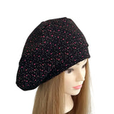 Black beret with pink polka dots on a mannequin head against a white background ireland