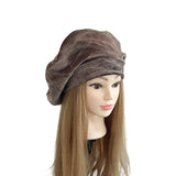 Brown turban on a mannequin head with long brown hair against a white background