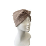 Beige headband on a mannequin head against a white background