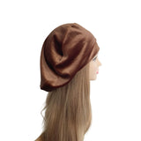 Brown beret on a mannequin head with blonde hair against a white background