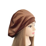Brown beret on a mannequin head with long hair against a white background