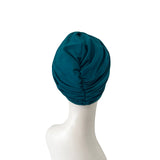 Teal headscarf on a mannequin head against a white background
