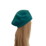 Teal beanie on a mannequin head against a white background