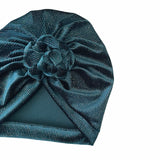 Teal velvet turban with a knot on a white background