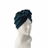 Navy blue headscarf with a flower on a mannequin head against a white background