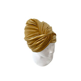 Gold turban on a mannequin head against a white background