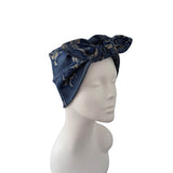 A navy blue silk-like headwrap with a gold dragon pattern, styled on a white mannequin head against a plain white background.