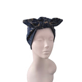 A navy blue satin headwrap with a gold dragon pattern, styled on a light gray mannequin head against a white background.