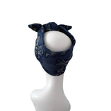 A navy blue fabric headwrap or turban with a subtle floral pattern, styled on a white mannequin head against a plain white background.