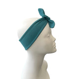 Teal headband on a mannequin head against a white background