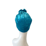 Blue velvet headscarf on a mannequin head against a white background
