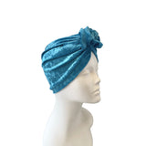 Blue velvet turban on a mannequin head against a white background