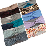 A set of twisted headbands displayed in two columns on a plain white background, showing multiple colors and patterns including solid beige, leopard print, floral print, and solid blue, purple, and gray.