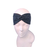 A black and gray leopard print twisted headband displayed on a light pink mannequin head against a plain white background.