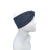 A black and gray leopard print twisted headband displayed on a white mannequin head in profile against a plain white background.
