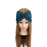 Mannequin head with long brown hair wearing a blue lace headband on a white background