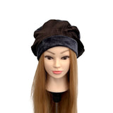 Mannequin head with a brown and black headscarf on a white background