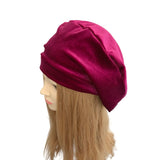 Mannequin head wearing a magenta turban on a white background