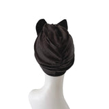 Black turban with cat ears on a white mannequin head against a white background