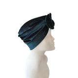 Blue textured headscarf with a flower on a mannequin head against a white background