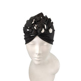Black headband with floral design on a mannequin head against a white background