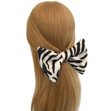 Zebra print hair bow on a mannequin head with blonde hair against a white background