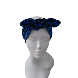 A blue and black patterned fabric headwrap or turban displayed on a white mannequin head against a plain white background.