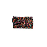 A black headband featuring an all-over dense leaf print in shades of red, orange, green, and pink, presented flat against a solid white background.