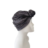Gray velvet turban on a mannequin head against a white background