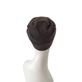 Brown turban on a mannequin head against a white background