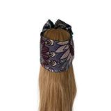 A long blonde wig with a matching patterned headband featuring a bow, displayed on a mannequin head against a plain white background.