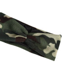 A close-up of a camouflage fleece headband with a twisted knot detail, featuring green, brown, and beige camo patterns on a white background.