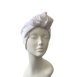 white velvet knot headband on a mannequin head against a white background