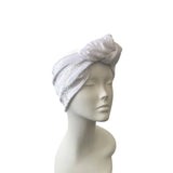 white knotted headband on a mannequin head against a white background