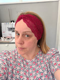 Person wearing a red headband in a sewing room