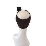 Black patterned headband on a white mannequin head against a white background