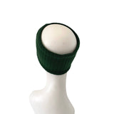 Green knitted beanie on a white mannequin head against a white background