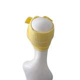 A yellow ribbed knit headband with a bow, displayed on a white mannequin head against a plain white background.