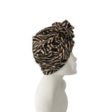 Leopard print turban on a mannequin head against a white background