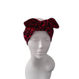 A red and black zebra-print headwrap styled on a white mannequin head against a plain white background.