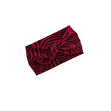 A knotted headband featuring a vibrant red and black wavy spiral pattern, displayed on a clean white background.